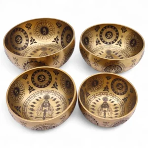 Set of 4 brass singing bowls etched with chakras and Om symbols for sound healing.