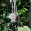 Tree of Life Silver Wire Gemstone Pendants - Pink Brown Black Three silver wire-wrapped gemstone pendants shaped like trees displayed against green leafy background.