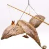 Handcrafted bird sculpture made from dried palm leaves and wood, suspended with strings against white background.