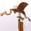 Handcrafted wooden dragon wind chime with bamboo tubes and natural rope details hanging outdoors.