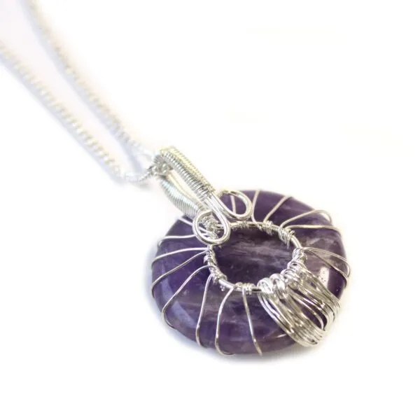 Amethyst donut pendant wrapped in silver wire on a fine sterling silver chain.