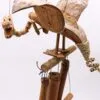 Hand-carved wooden dragon sculpture perched above bamboo wind chimes made from natural materials.