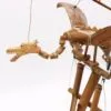 A handcrafted wooden dragon marionette with bamboo wings suspended by strings against a white background.