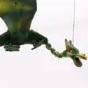 A handcrafted green wooden dragon marionette with painted details hanging against a plain white background.