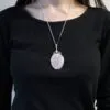 Rose Quartz Pendant Necklace Silver Wire Wrapped Design A silver wire-wrapped rose quartz pendant necklace worn over a plain black top.