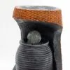 Modern black resin tabletop fountain with clear glass sphere and orange woven accent band.