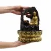 Golden Buddha Tabletop Fountain Resin Sculpture - Lotus Base A small golden Buddha tabletop water fountain with copper bowls held gently in two hands.