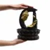 Golden Buddha Head Sculpture Resin Black Base - Lotus Frame Hands holding golden Buddha head sculpture with black lotus base and crescent stone-effect frame.