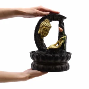 Hands holding golden Buddha head sculpture with black lotus base and crescent stone-effect frame.
