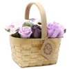 Handmade wicker basket with lilac and white soap flowers, perfect for decorative or gift use.
