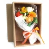 Elegant orange and yellow soap flower bouquet gift box with ribbon and tissue wrapping.