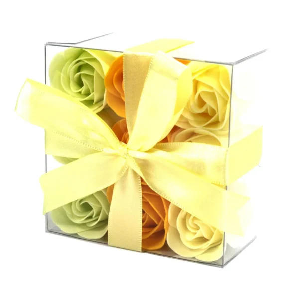 Pastel green, yellow, and orange soap roses in a clear acrylic gift box with yellow ribbon.