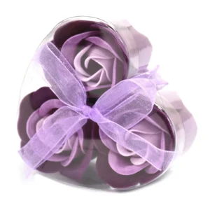 Heart-shaped transparent box with three purple soap roses and a sheer lavender ribbon bow.