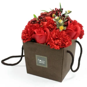 A handmade red rose and carnation flower arrangement in a dark brown square gift box.