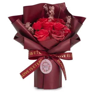 Red soap rose bouquet with pink baby’s breath, burgundy wrap, and “LOVE IS ETERNAL” ribbon.