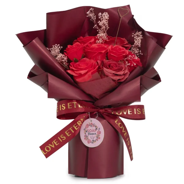 Red Soap Flower Bouquet Burgundy Wrap - Eternal Love Theme Red soap rose bouquet with pink baby’s breath, burgundy wrap, and “LOVE IS ETERNAL” ribbon.
