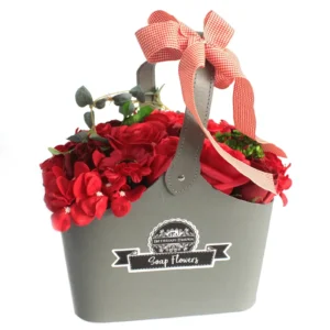Grey container with red soap flowers and a red-and-white gingham bow gift arrangement.