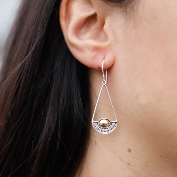 Silver geometric drop earring with gold accent on ear, modern minimalist jewellery design.