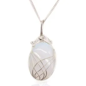 Elegant silver wire-wrapped moonstone pendant necklace with iridescent glow on a delicate chain.