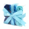A clear gift box filled with blue rose-shaped soap flowers tied with a light blue satin ribbon.