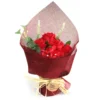 A red soap flower bouquet with roses and hydrangeas wrapped in deep red mesh and raffia ties.