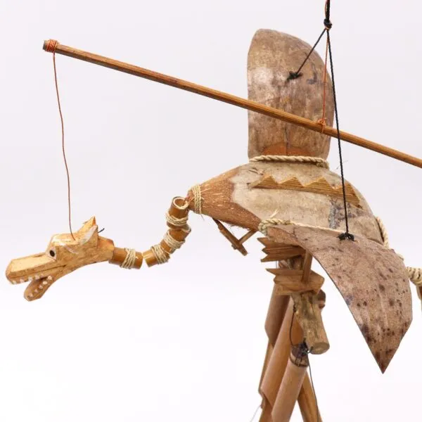 Handcrafted wooden dragon marionette with movable wings, folk-inspired design, and natural brown finish.