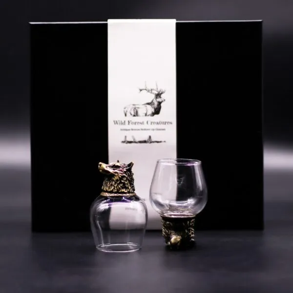 Wild Forest Creatures Bronze Glasses - Black Box Gift Set Two bronze-based animal head glasses with a black “Wild Forest Creatures” box on dark background.
