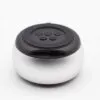 A small round silver and black Bluetooth speaker with top control buttons and charging port.