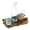 Aqua Glass Bottle And Cups Set On Natural Driftwood Base Hand-blown aqua glass bottle and cups displayed on natural driftwood home decor piece.