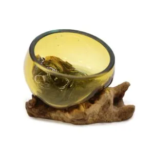 Handcrafted yellow-tinted glass bowl fused to natural driftwood base, decorative rustic art piece.