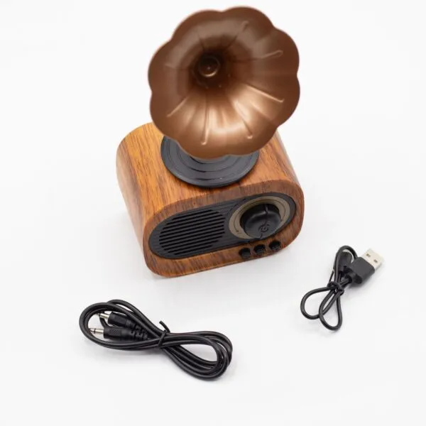 A retro wooden Bluetooth speaker with a bronze gramophone horn and two black charging cables.