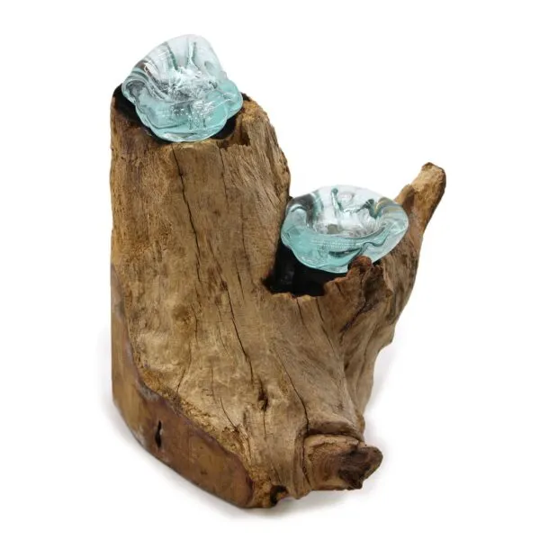 Molten glass sculpture resting on reclaimed driftwood base, blending smooth blue-green glass with rustic wood.