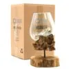 Hand-blown glass bowl resting on natural driftwood base with packaging labelled “Ancient Wisdom Indonesia.”