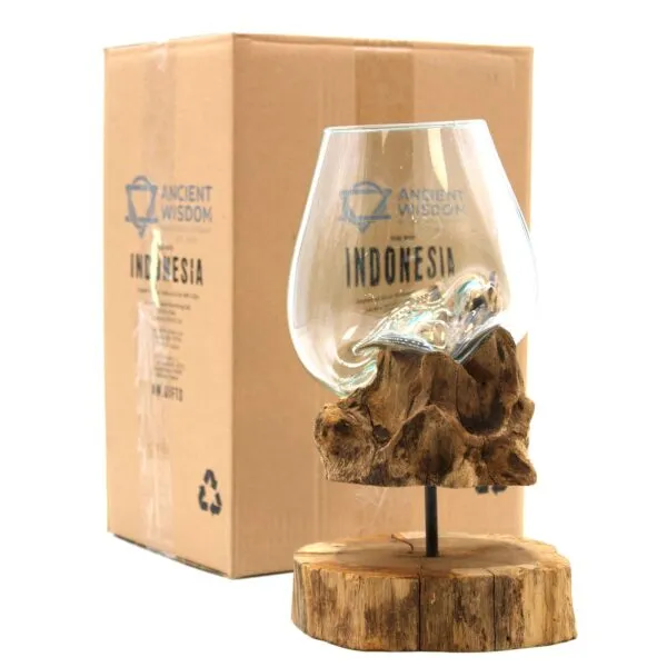 Hand-blown glass bowl resting on natural driftwood base with packaging labelled “Ancient Wisdom Indonesia.”