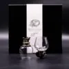Two crystal glasses with bronze dragon bases in front of a black “Mystical Creatures” gift box.