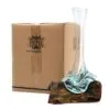 Hand-Blown Glass Vase Green Tint on Natural Wooden Base A hand-blown glass vase melted onto natural wood beside a brown HOME-branded cardboard box.