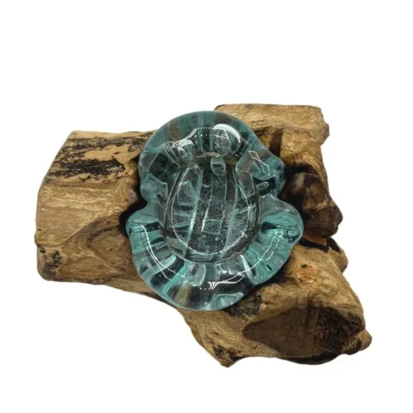 Hand-blown aqua glass bowl resting on natural driftwood base, rustic decorative art piece