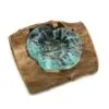 A turquoise hand-blown glass bowl fused to a rugged driftwood base for natural home décor.