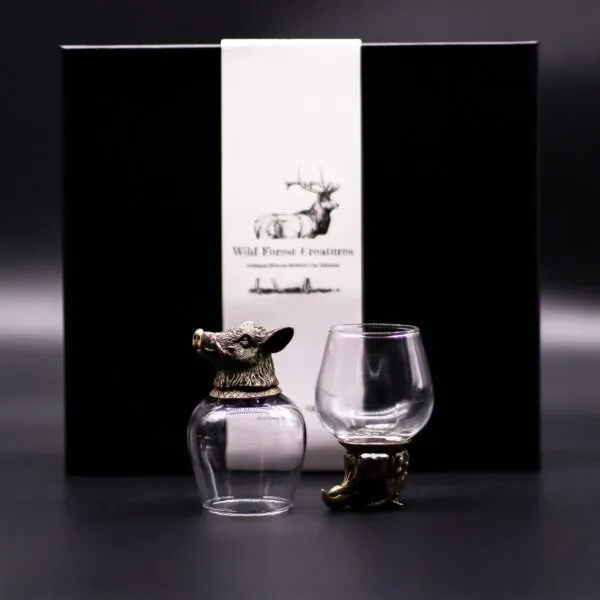 Wild Forest Creatures Glassware Set - Bronze Animal Design Two ornate glass drinkware pieces with bronze animal designs in front of a black luxury gift box.
