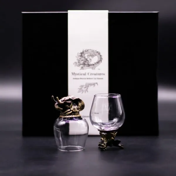 Two ornate glass cups with antique bronze animal bases displayed before a black “Mystical Creatures” box.