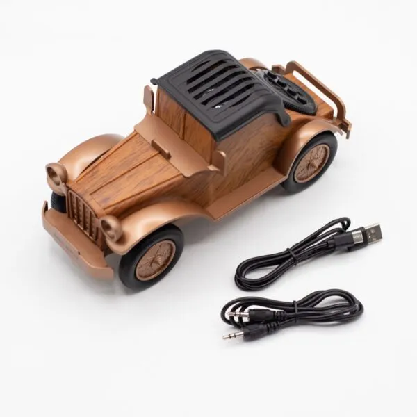 A vintage-style bronze and wood Bluetooth speaker shaped like a classic car with USB and aux cables.