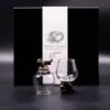 Two bronze-based dragon-themed glass cups in front of a black Mystical Creatures gift box.