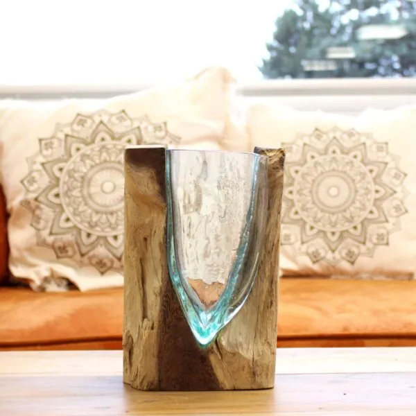 Hand-blown glass and natural wood centerpiece on a wooden table in a cosy, sunlit living room.