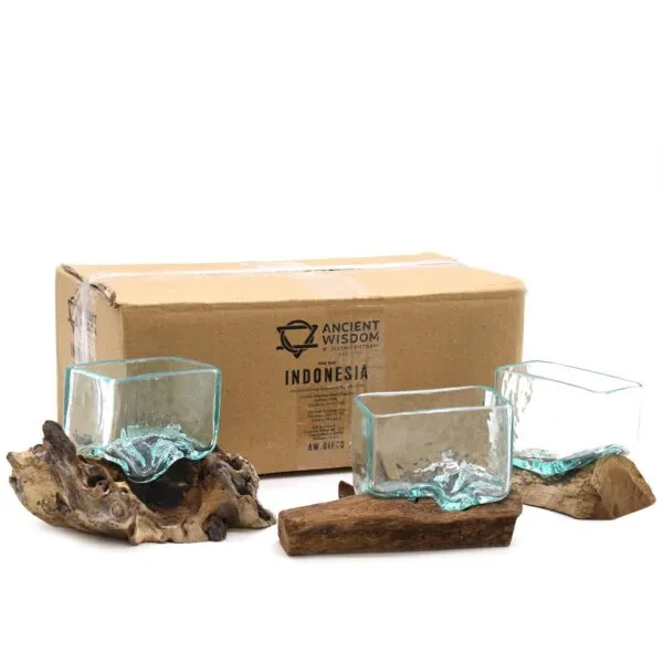 Hand-blown glass bowls on natural driftwood bases displayed before an Ancient Wisdom Indonesia box.