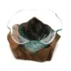 Hand-blown glass bowl with green tint resting on natural driftwood base, artistic home décor piece.