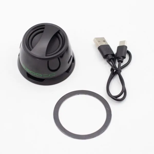 A black portable Bluetooth speaker with charging cable and rubber base ring on a white background.