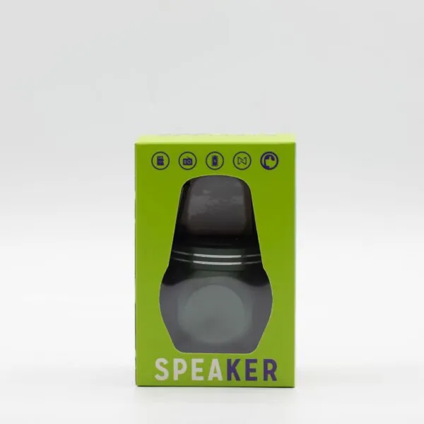 A small cylindrical portable speaker in metallic grey inside a bright green retail packaging box.