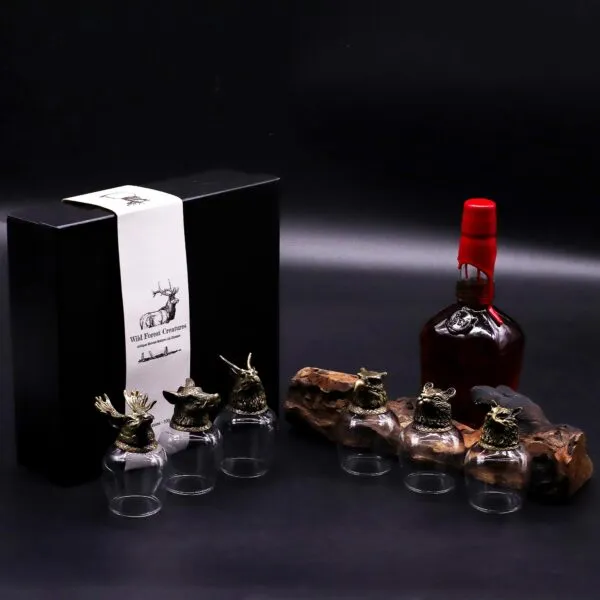 Wild Forest Creatures Whiskey Set - Bronze Animal Head Glasses Luxury whiskey gift set with bronze animal head glasses and dark bottle on wooden display.