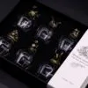 Luxury bronze creature glass set in black box with ornate mythical designs.