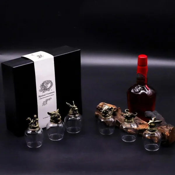 Luxury bronze mythical creature glassware set with whiskey bottle on dark elegant background.